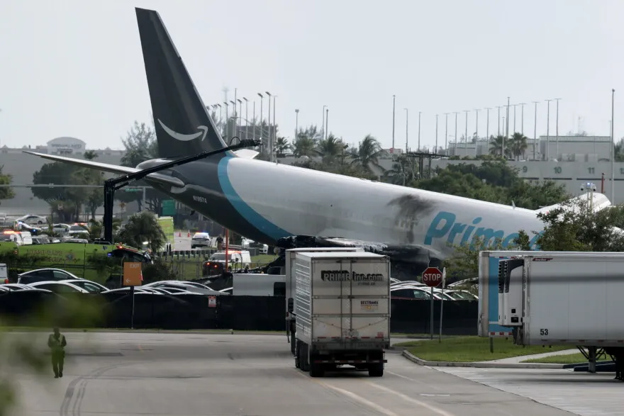 Amazon Cargo Plane Crash In Miami Kills Five Federal investigators are examining the cause of a fiery Amazon cargo plane crash Miami incident that killed five people after a Boeing 767 ran off the runway at Miami International Airport, striking an SUV and a van carrying cleaning crew members. The National Transportation Safety Board has focused its investigation on whether the aircraft touched down too late in its landing sequence to stop safely within the available runway length, with early evidence suggesting the plane remained airborne further down the runway than expected. The crash, which occurred Sunday, immediately halted flight operations at one of the country's busiest international airports, causing widespread delays and cancellations that affected thousands of travelers as authorities worked to secure the crash site and begin their investigation. This incident represents a significant setback for cargo aviation safety, given the aircraft's role transporting goods for one of the world's largest e-commerce companies, whose extensive logistics network depends heavily on reliable air cargo operations across numerous airports nationwide. Aviation safety experts note that runway overrun incidents, while relatively rare, often result from a complex combination of factors including aircraft speed, weather conditions, and pilot decision making during the critical final moments of landing approach and touchdown procedures. The victims killed in the crash included ground personnel who were performing routine cleaning duties near the runway area when the aircraft's uncontrolled path intersected with their vehicles, highlighting the risks ground crew members face even when not directly involved in flight operations. Airport officials worked quickly to reroute flights and manage the significant operational disruption caused by the runway closure, though the scale of delays and cancellations reflects the airport's status as a major hub for both passenger and cargo aviation traffic in the region. The cargo airline operating the flight has expressed condolences to the victims' families while committing full cooperation with investigators working to determine the precise sequence of events leading to the crash and any contributing factors that investigators may identify. This incident adds to ongoing industry discussions about cargo aviation safety standards, particularly regarding older aircraft models still actively used in cargo operations, though investigators have not yet indicated whether aircraft age or maintenance played any role in this specific incident. Regulatory attention following this crash will likely focus on reviewing landing procedures and safety protocols at the airport, along with broader questions about runway safety margins for aircraft models similar to the one involved in this particular incident. As the investigation continues, aviation officials and the broader industry await findings that could inform future safety protocols. For the families of those killed, including ground crew members simply performing routine duties, this tragedy represents a devastating and sudden loss connected to what should have been a routine cargo flight operation.